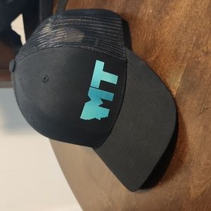 Black snap back trucker hat with teal MT (Montana) logo